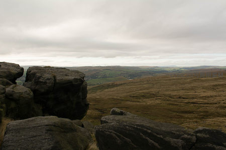 多云天气下的高原岩石与风力发电场景观
