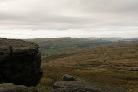 巨石旁的开阔视野：风车点缀的连绵山丘
