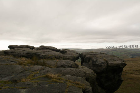 山巅巨岩缝隙望见风车群落