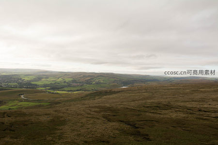 云层下的山谷风光与风力发电机群