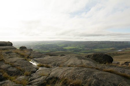 岩石平台上的水洼倒映远方城镇风光