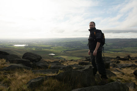 山顶行者凝视远方乡村景色