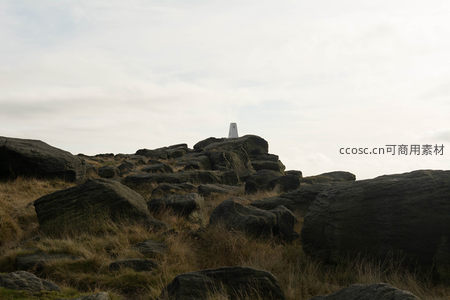 荒草覆盖的山岩上孤寂的测量标