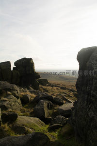 峭壁边缘的岩石剪影与远方平原