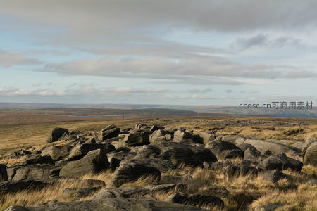 广阔荒原上散落巨石与低垂云层