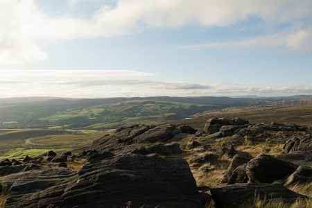 日光洒落，岩石群与绿色山谷的光影交响