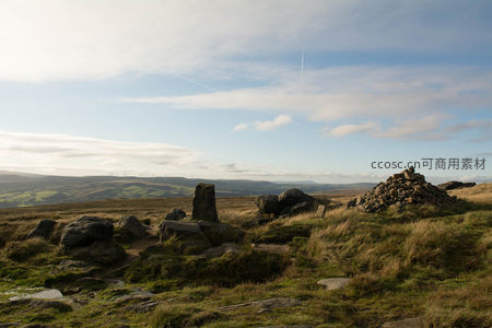 山野巨石与远处风车构成的宁静风景