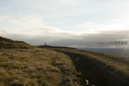草坡远眺：云隙光洒向孤独旅人