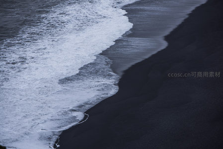 浪花轻吻黑色沙滩的瞬间