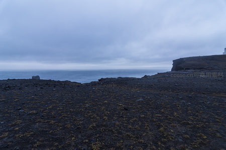 阴云笼罩的黑色火山岩海岸