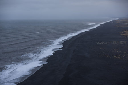 黑沙滩与海浪的静谧交响