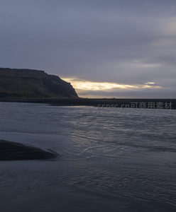 水流轻抚黑色滩涂的瞬间
