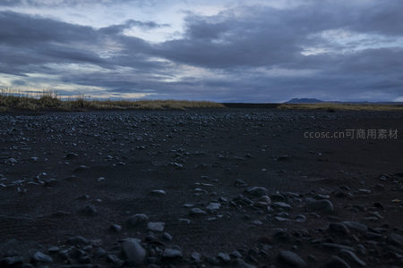暮色下的黑沙滩与远山云影