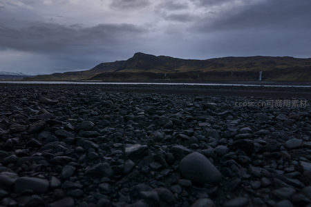 火山石滩与远方山脉的静默对话