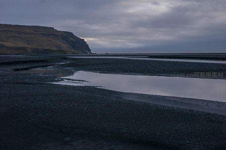 黑沙滩与远山的静谧黄昏