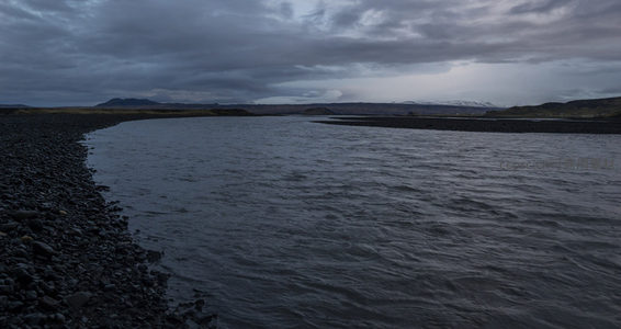 蜿蜒河流绕过黑石滩延伸远方