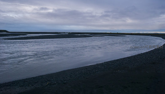 蜿蜒河流与黑沙滩景致