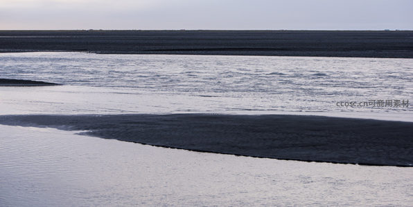 黑沙滩与海浪交织的静谧海岸线