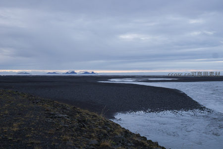 黑沙滩与远山剪影
