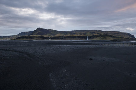 黑沙滩前的瀑布山景