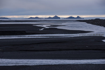 黑沙滩与远山晨曦的静谧画卷