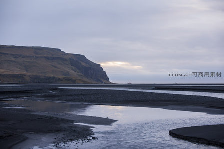 黑沙滩与远山的静谧黄昏