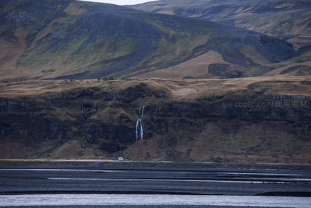 山崖瀑布倾泻而下，黑沙滩静谧辽阔