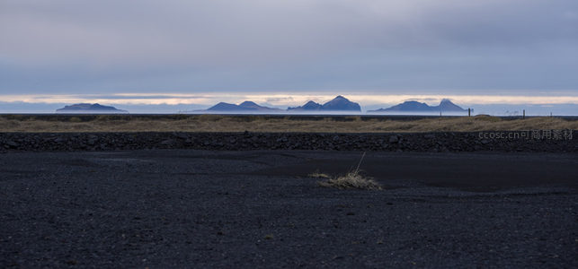 黑沙海岸线与连绵山峦的静谧