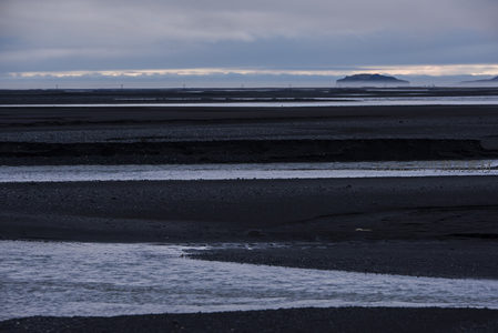 潮汐退去后黑沙滩上的水道