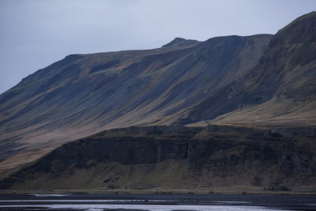 山体陡峭显岩层，车行谷底渺如尘