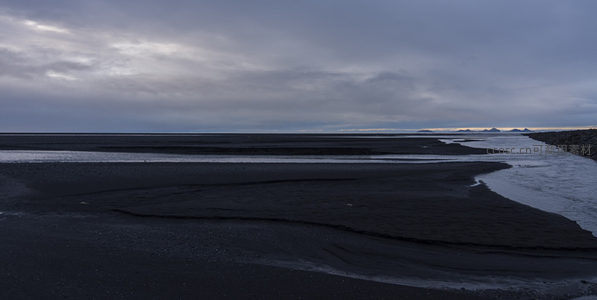 蜿蜒河流穿过广袤黑沙平原