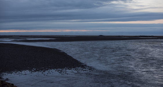 蜿蜒河流旁的黑色沙滩