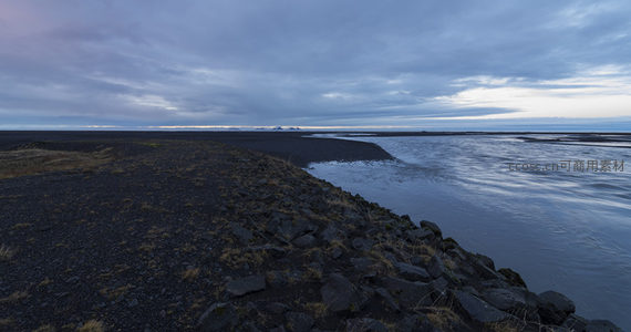 黑沙滩与河流交汇的宁静黄昏