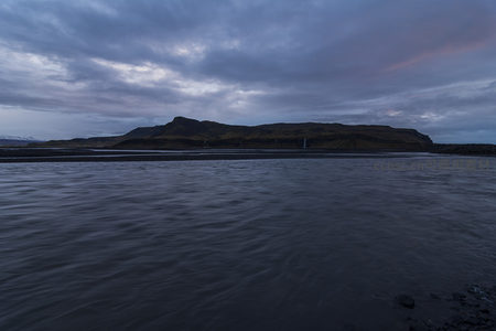 暮色中河流倒映着阴云密布的天际