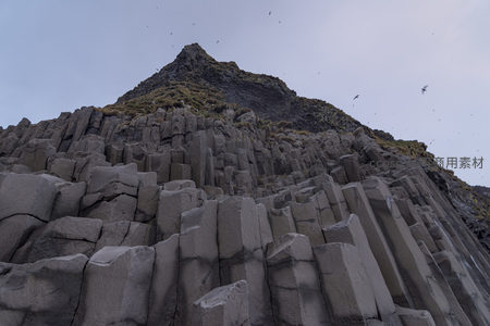 仰望陡峭山崖上的巨型玄武岩柱
