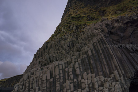 云层下倾斜的柱状玄武岩山体