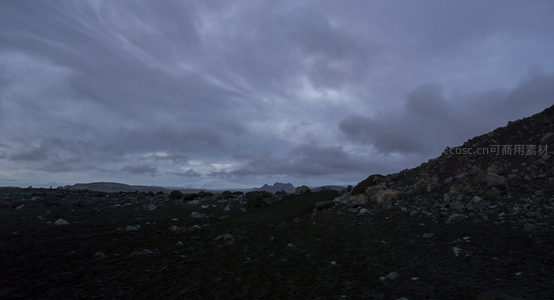 暮色下的火山岩荒原，云层低垂如幕