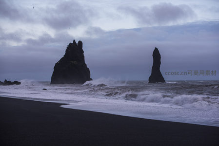 双峰巨岩守海岸，浪花飞舞黑沙滩