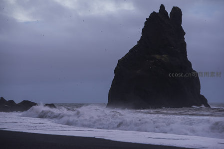 巨岩如剑刺苍穹，浪花碎玉洗黑沙