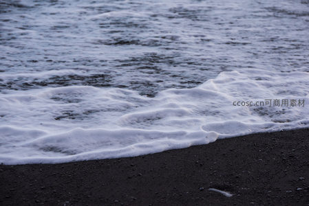 泡沫轻吻黑沙，海浪温柔时刻