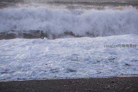 浪花翻滚覆盖黑色海滩