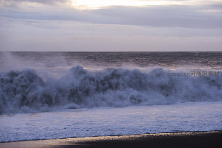 狂澜怒卷黑沙滩，雾气氤氲日将沉