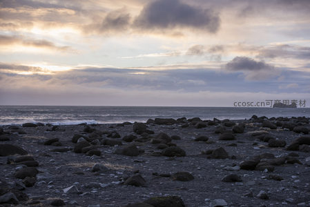 黄昏海岸线，黑沙滩与远山剪影
