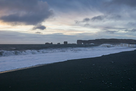 黄昏时分的黑沙滩与远山剪影