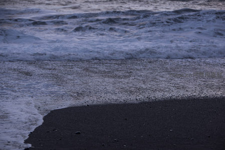 夜幕降临前的黑沙滩浪花特写