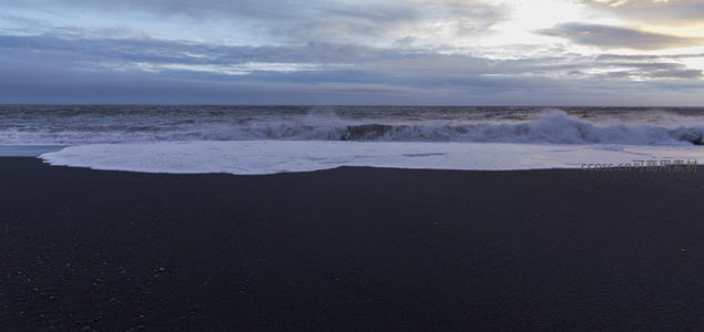 暗色沙滩与汹涌白浪的交响