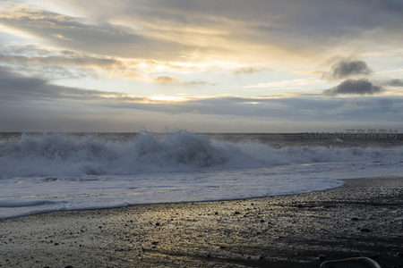 暮色中海浪翻腾冲刷海岸