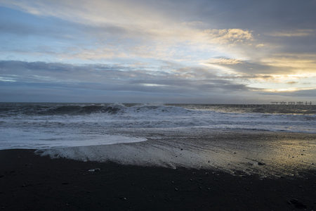 黑沙滩上奔腾的白色浪花