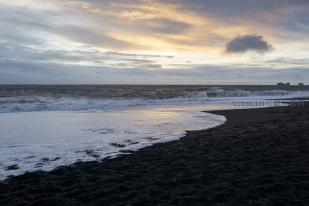 夕阳下的黑沙滩与温柔潮汐