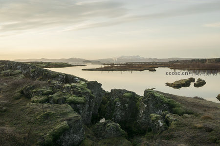 湖岸苔岩与雪山倒影的壮丽风光